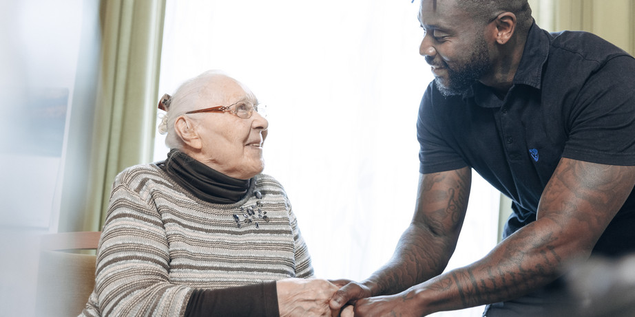 Pflegekraft kümmert sich um Bewohnerin